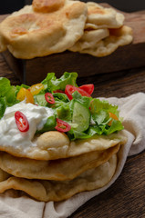 Navajo fried bread with green salad and yougurt on wooden