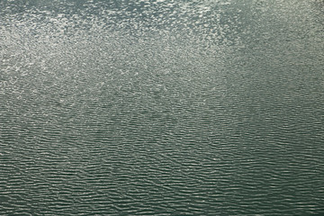 Natural liquid background pattern, surface of water with light ripple