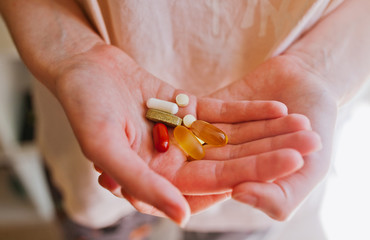 A handful of multi-colored tablets or vitamins in the palm of your hand