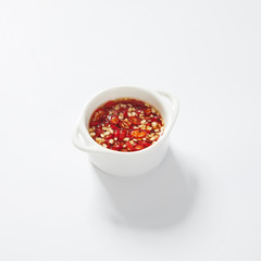 Thai Chili fish sauce in a white cup on white background
