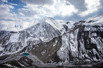 Obraz premium Beautiful panorama of the Caucasus mountains with clouds above them and a lake