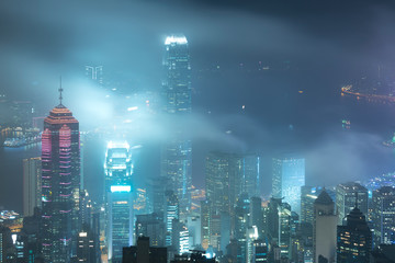 Misty night view of Victoria harbor in Hong Kong city