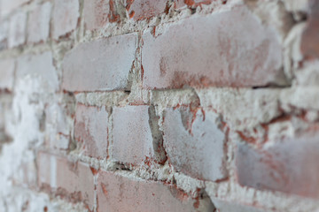 Old brick wall with white paint background texture close up. Side view, low depth of field.