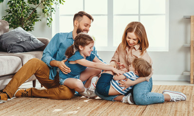 Cheerful parents with kids having fun at home.