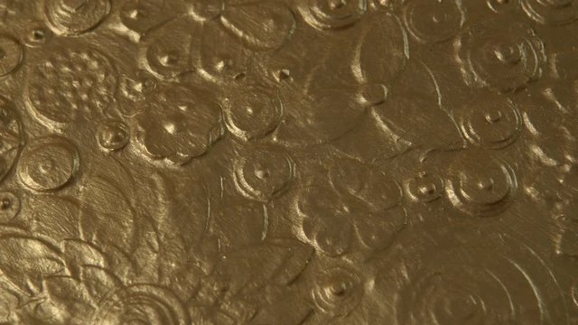 Abstract gold flower art close up. Golden floral background, texture painting covered with metallic dust. Shining slow motion drapery loop. Luxurious Diwali yellow grungy paint surface rotation. 4k.