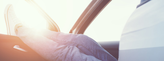 Woman resting in the car with shoes in the window. Wide screen, panoramic