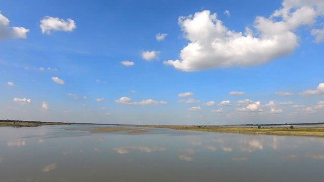 river water reflection with clear blue sky with many small cloud patch