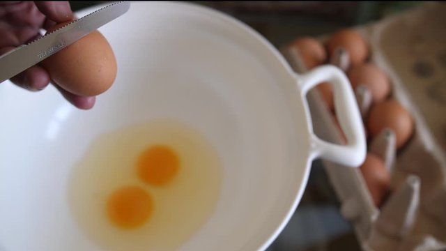 Ei wird aufgeschlagen um Eiwei&szlig; und Eigelb zu separieren und dieses in einer Schale verr&uuml;hrt um es in Teig oder Omlett zum Fr&uuml;hst&uuml;ck zu verarbeiten