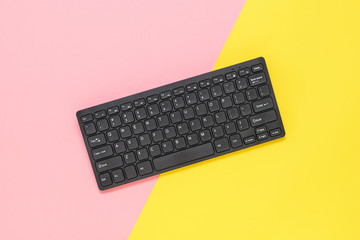 A small wireless keyboard on a red and yellow background.