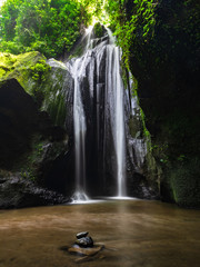 Tropical landscape. Waterfall in hidden canyon. Travel and adventure concept. Soft focus. Slow shutter speed, motion photography. Landscape background. Krisik waterfall, Bangli, Bali