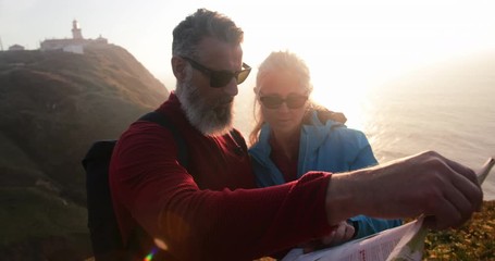 Close up of senior couple checking map on seaside cliff - Powered by Adobe