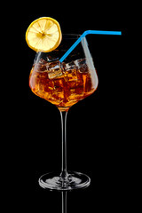 A glass of alcohol with ice and a slice of lemon