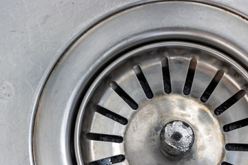 A metal sink with drain hole, macro view. Mechanically adjustable drain plug closeup.