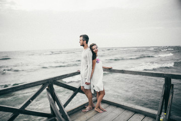 Happy lovers have a cheerful vibes on sea beach at sunset 