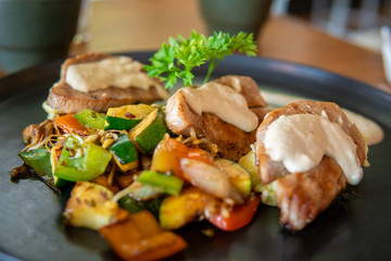 Fish dish with red tuna steak on mashed potatoes with grilled vegetables.