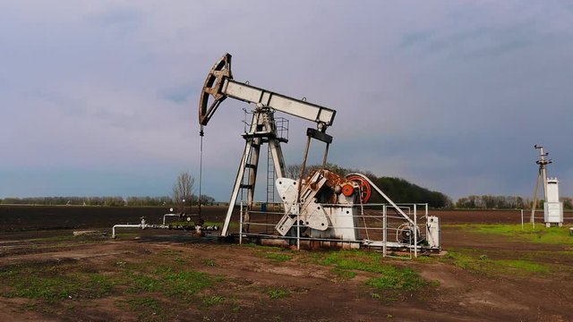 Working oil pumps against sun. Oil pump jack. oil rocking oil field