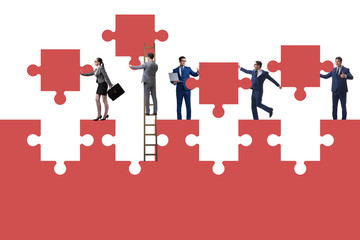 Fototapeta premium Businessman in teamwork concept with jigsaw puzzle
