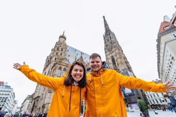 couple travelers in yellow raincoat in front of vienna cathedral church