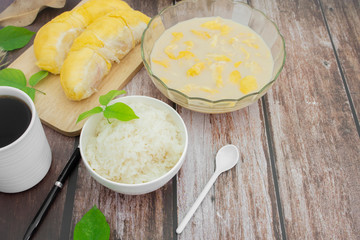 Sticky rice with durian on a wooden background.