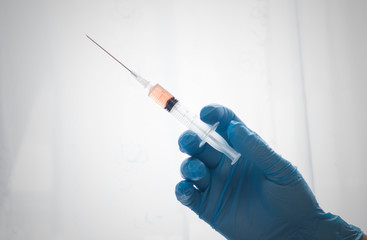 A hand with glove holding a vaccine. handing a injection. 