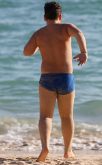 Fototapeta na wymiar A man in swimming trunks on the seashore.