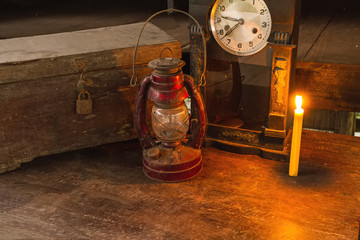 Vintage oil lamp ,old wooden box ,alarm clock and candlelight on old wooden touch-up in still life concept