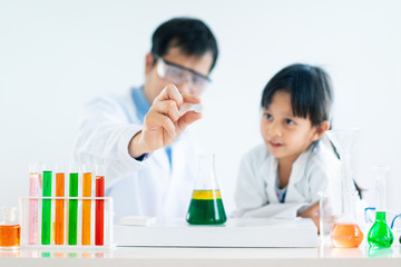 Asian father and little daughter make an experiment about phase separation of oil and water and how...