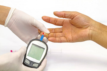blood glucose meter, the blood sugar value is measured on a finger by  female doctor in white medical gloves