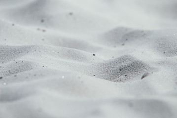 Close-up of white sea sand on a deserted beach. Concept of holidays and bright Sunny days. Selective focus macro shot with shallow DOF