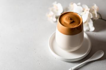 coffee dalgona in a glass on a light background, place for text