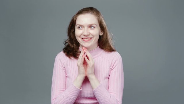 Video of plotting woman in pink turtleneck