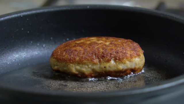 Appetizing cutlet close up fried in a frying pan. Juicy delicious meat cutlets in a frying Pan are Fried On the Stove in oil. Roasted cutlets in a pan. Frying process