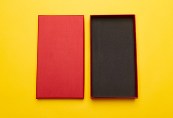 Red box product packaging isolated on yellow background. Flat lay Top view.