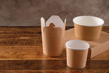 Street fast food paper cups, plates and containers. Eco-friendly food packaging on wooden background. Carering of nature and recycling concept.