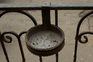 metal forged cast iron empty ashtray without cigarettes at the entrance to a cafe or restaurant