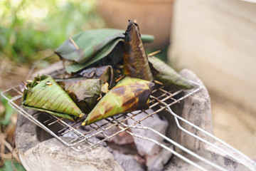 Grilling coconut sticky or glutinous rice in banana leaves