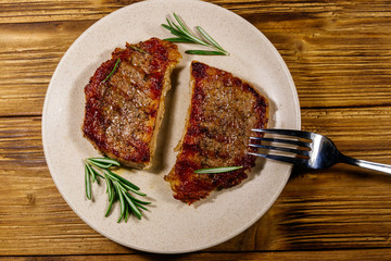 Grilled pork steaks with rosemary on wooden table. Top view
