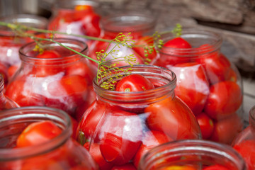 Pickling (canning) the tomatoes.