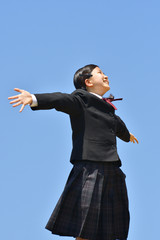 青空で両手を広げる女の子