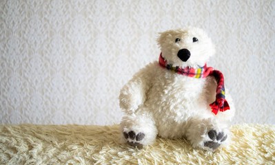 An old stuffed polar bear on the sofa.
