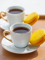 Coffee cup and macaroons on wood table. 