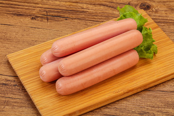 Tasty meat sausages over board