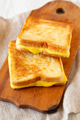 Homemade Grilled Cheese Sandwich on a rustic wooden board, low angle view. Close-up.