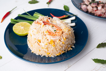 Fried rice with shrimp  and squid on the blue  dish on wooden table
