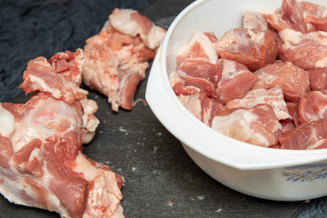 A piece of pork meat on the table, sliced for cooking.