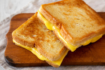 Homemade Grilled Cheese Sandwich on a rustic wooden board, side view. Close-up.