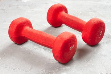 Two red dumbbells placed side by side
