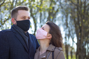 Masked young couple walking in the park