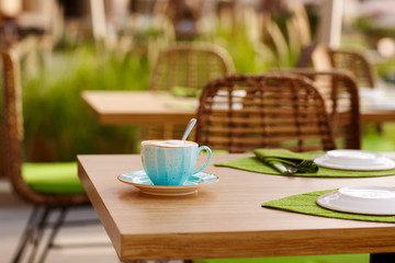 Morning coffee on the cozy cafe terrace. A Cup of coffee is on a table in an outdoor cafe