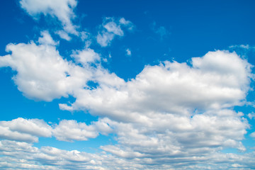 Naklejka na ściany i meble Horizontal view of a light, blue sky with white clouds. Airy, vibrant atmosphere